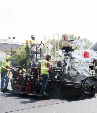 Workers on paving equipment
