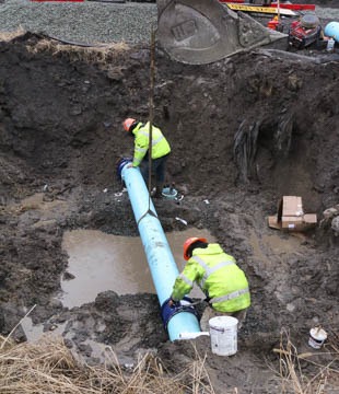 Two workers placing water pipe